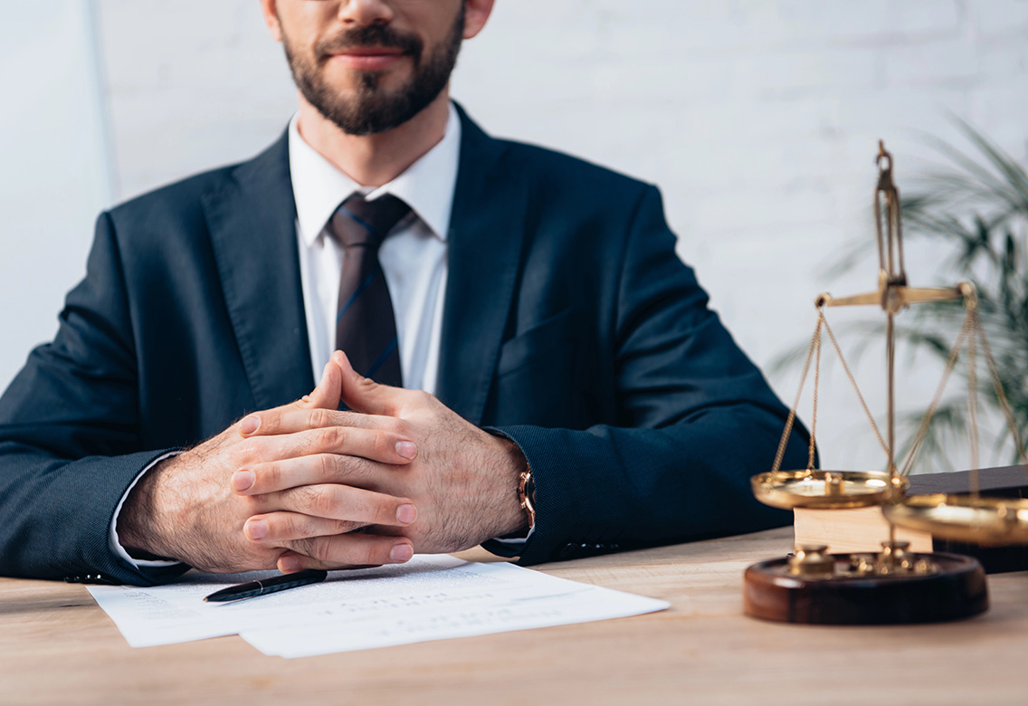 abogado-sentado-manos-apretadas-escritorio